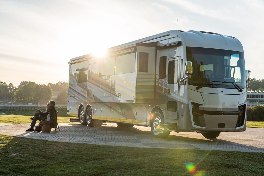 Couple enjoying sunrise beside the Cornerstone Series 6 coach